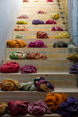 In Jaisalmer’s desert fortress, a stone city perched on a rocky hill surrounded by scorched sand, traditional Rajastani turbans dry on a stairwell.